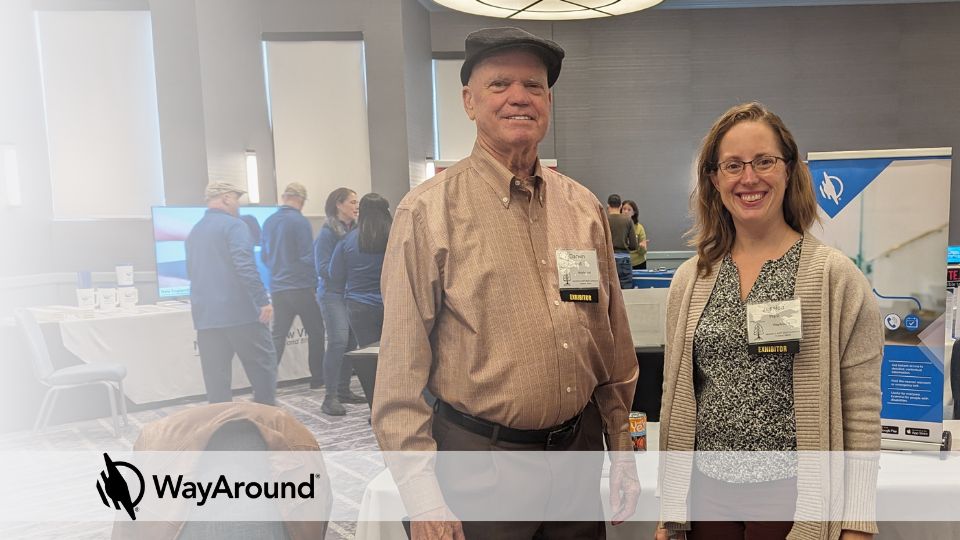 Darwin Belt and Jessica Hipp standing in front of a WayAround exhibit booth